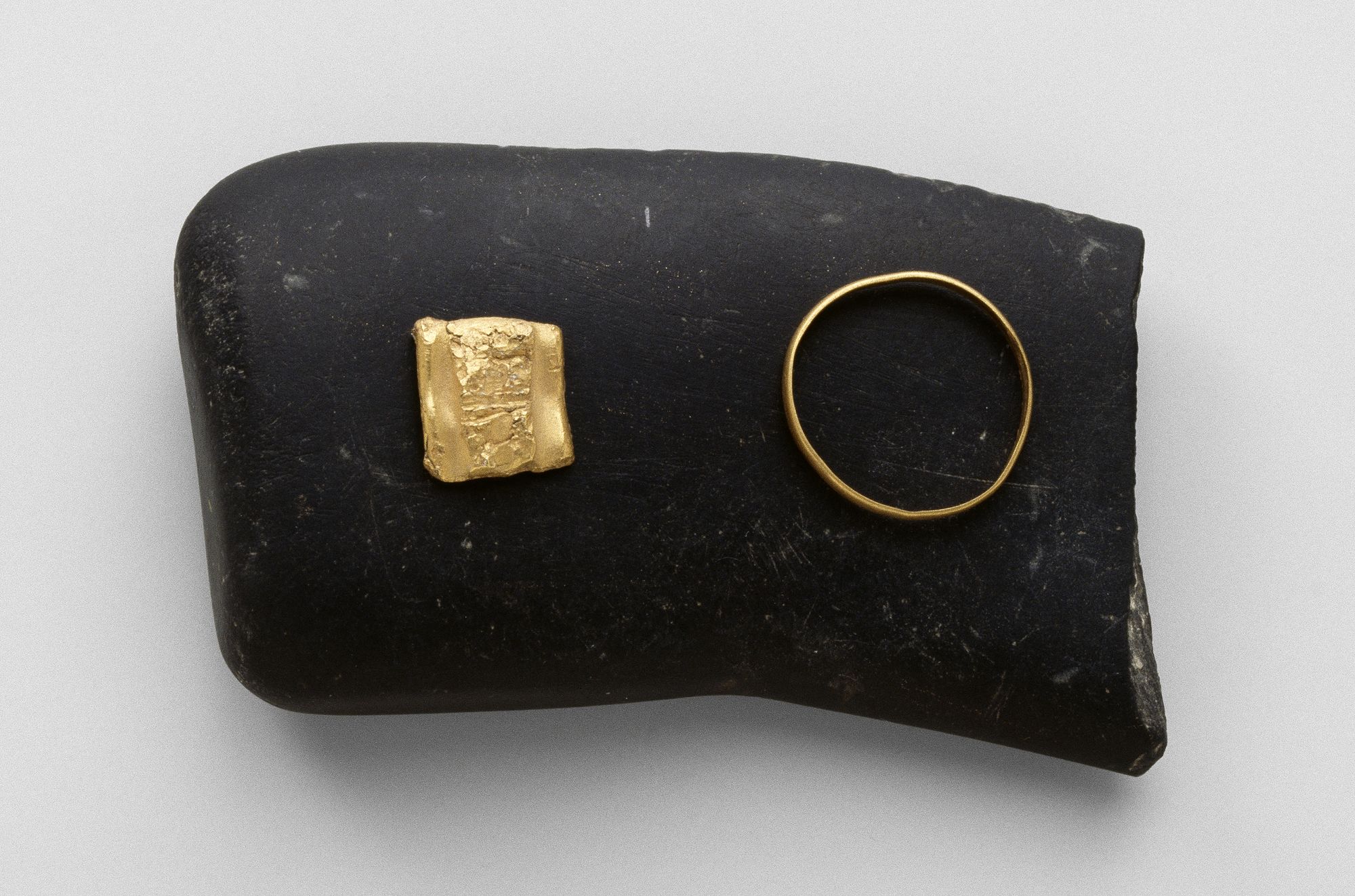 Lingot et anneau posés sur une pierre de touche Lingot et anneau posés sur une pierre de touche