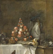 chien devant une table dressée avec une pyramide de fruits